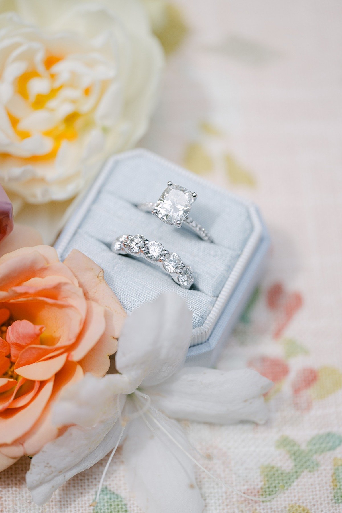 pastel blue velvet ring box with emerald cut engagement ring