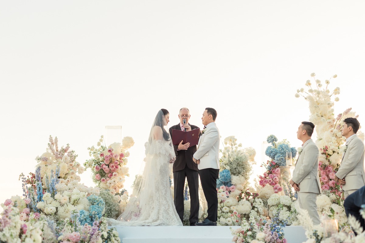 sunset wedding ceremony with pastel pink and blue floral installation