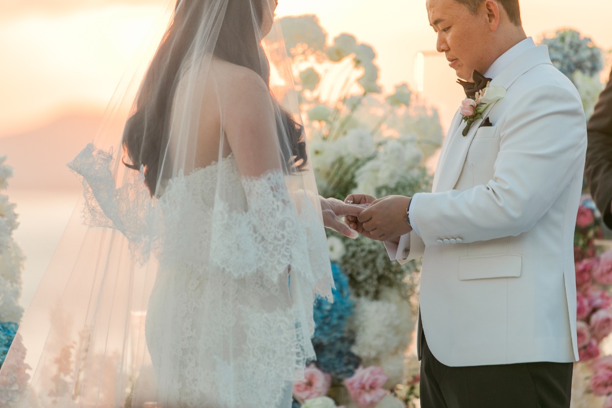 sunset wedding with bride in lace dress and groom in white jacket