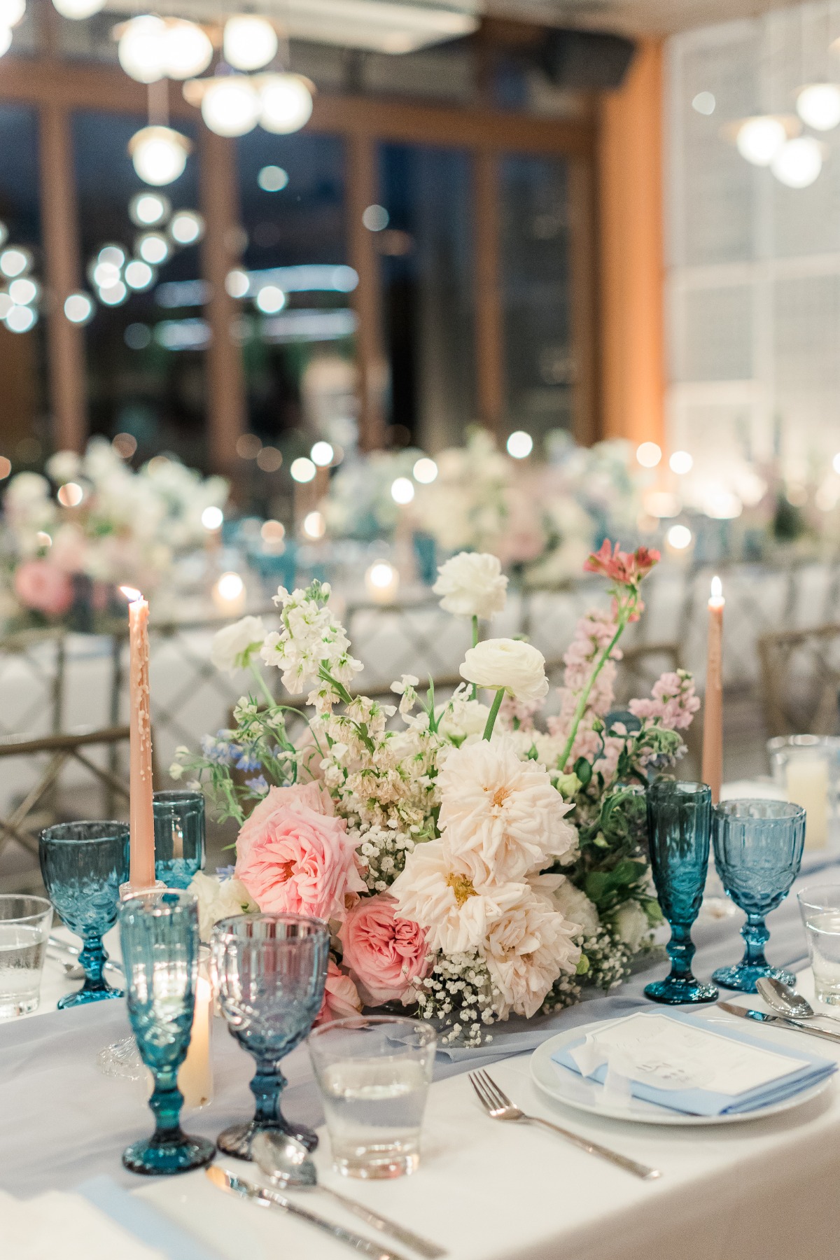 pastel wedding reception floral arrangements with blue glasses