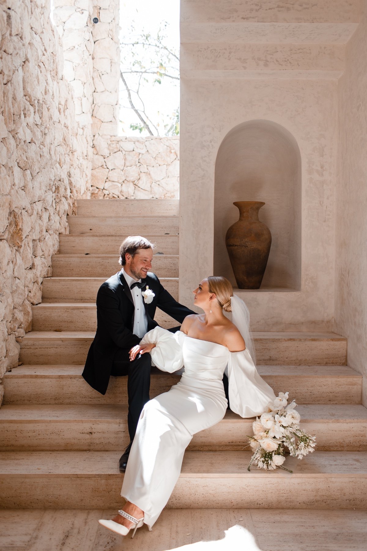 bride and groom on steps at resort in mexico