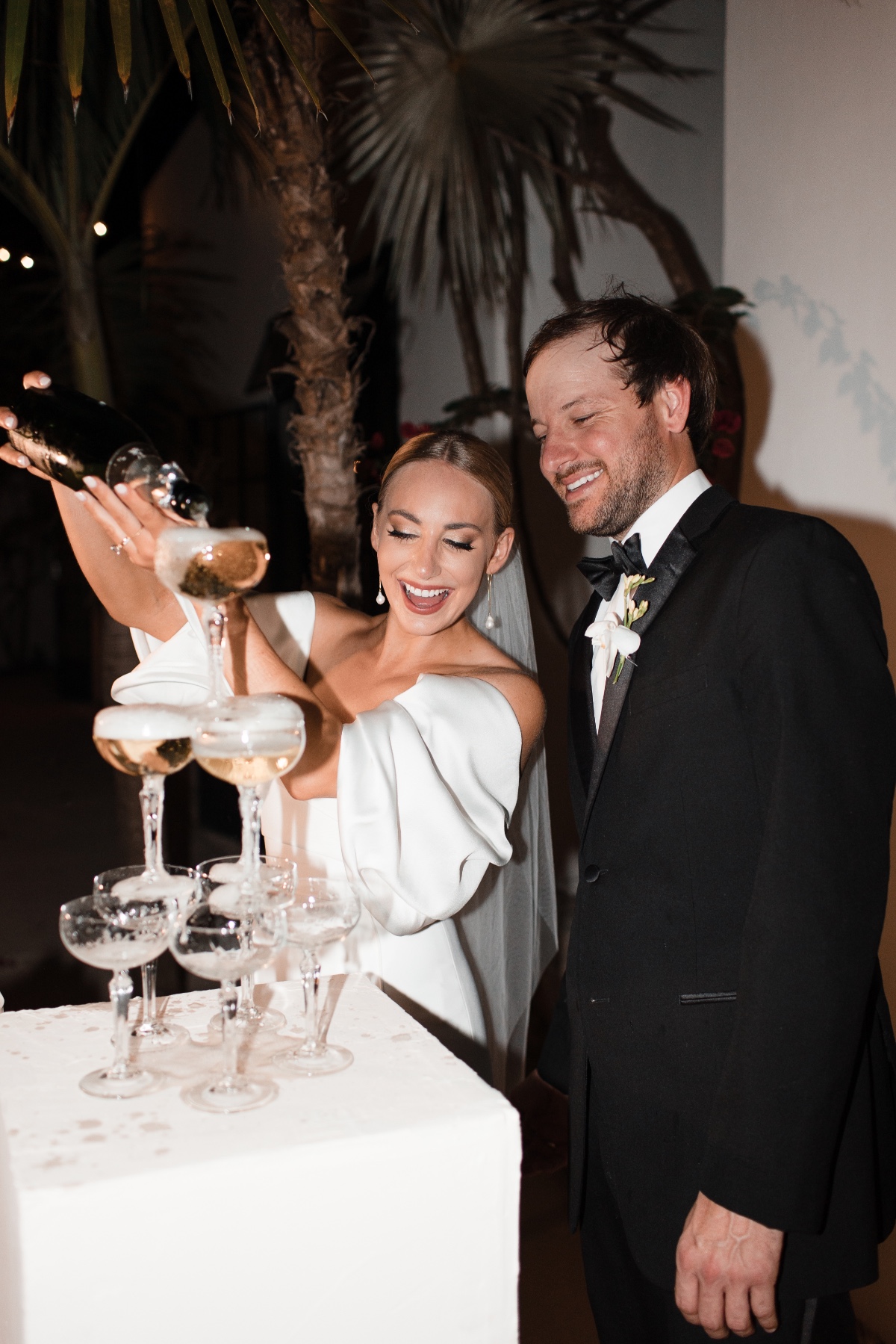 bride and groom pour a champagne tower