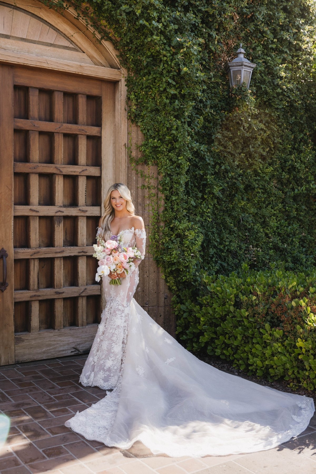 bride in lace galia lahav gown and pastel bouquet