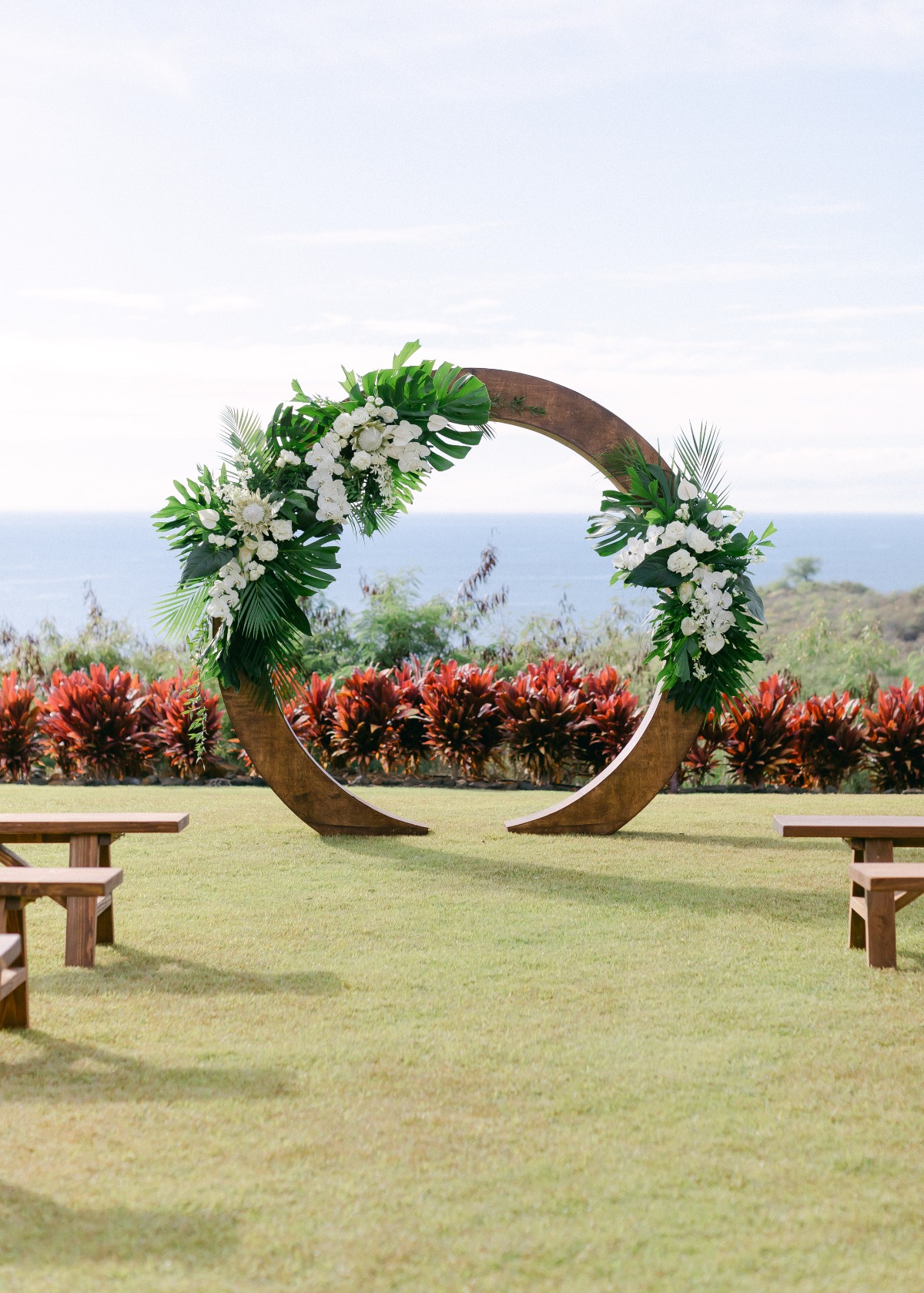 tropical wooden wedding arch with monstera leaves