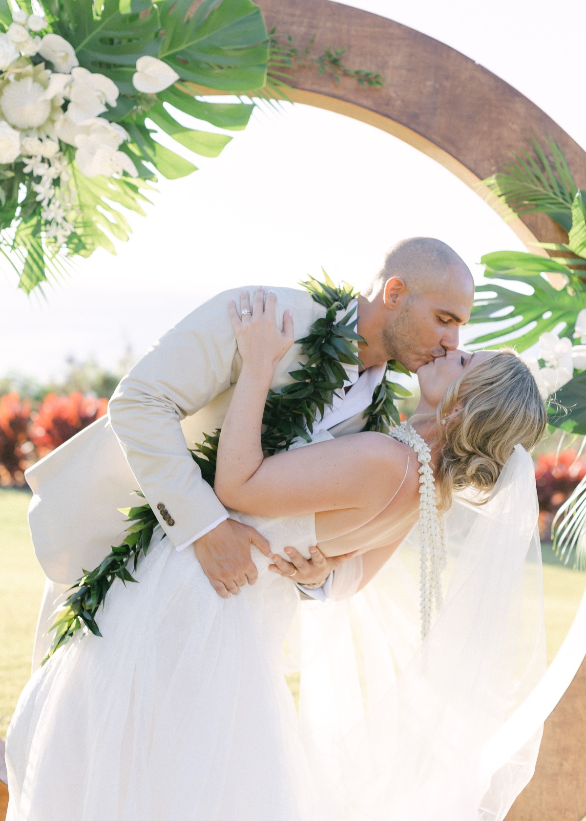 bride and groom exchange leis in hawaiian wedding ceremony