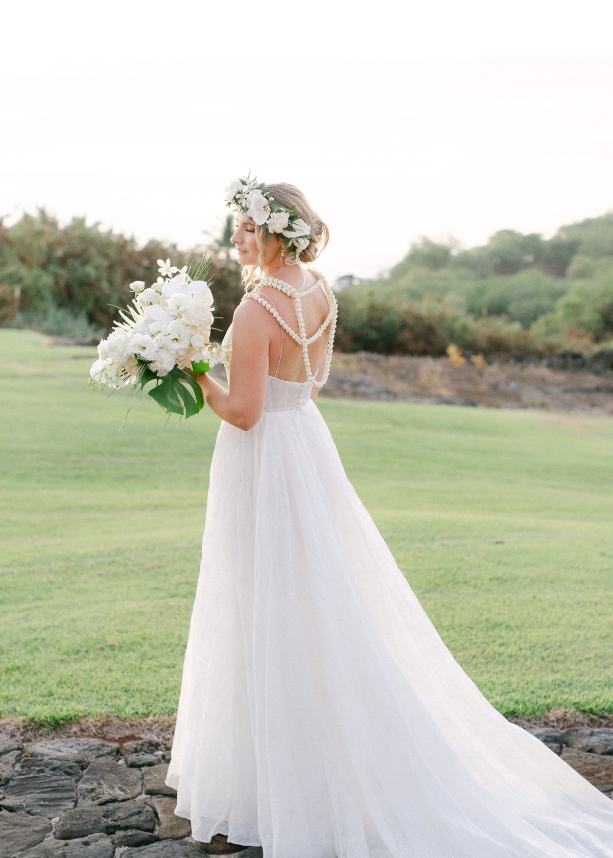 bride in a line gown in hawaii with flower crown and lei