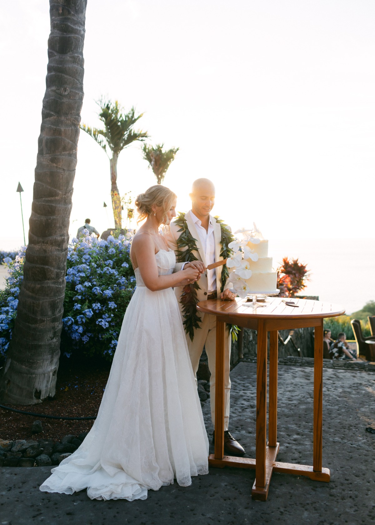 bride and groom cut wedding cake at tropical wedding