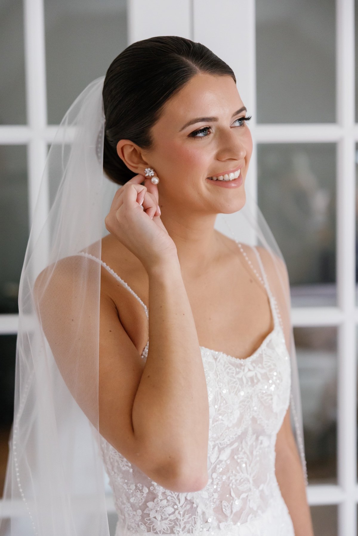 bride putting on earrings getting ready photo