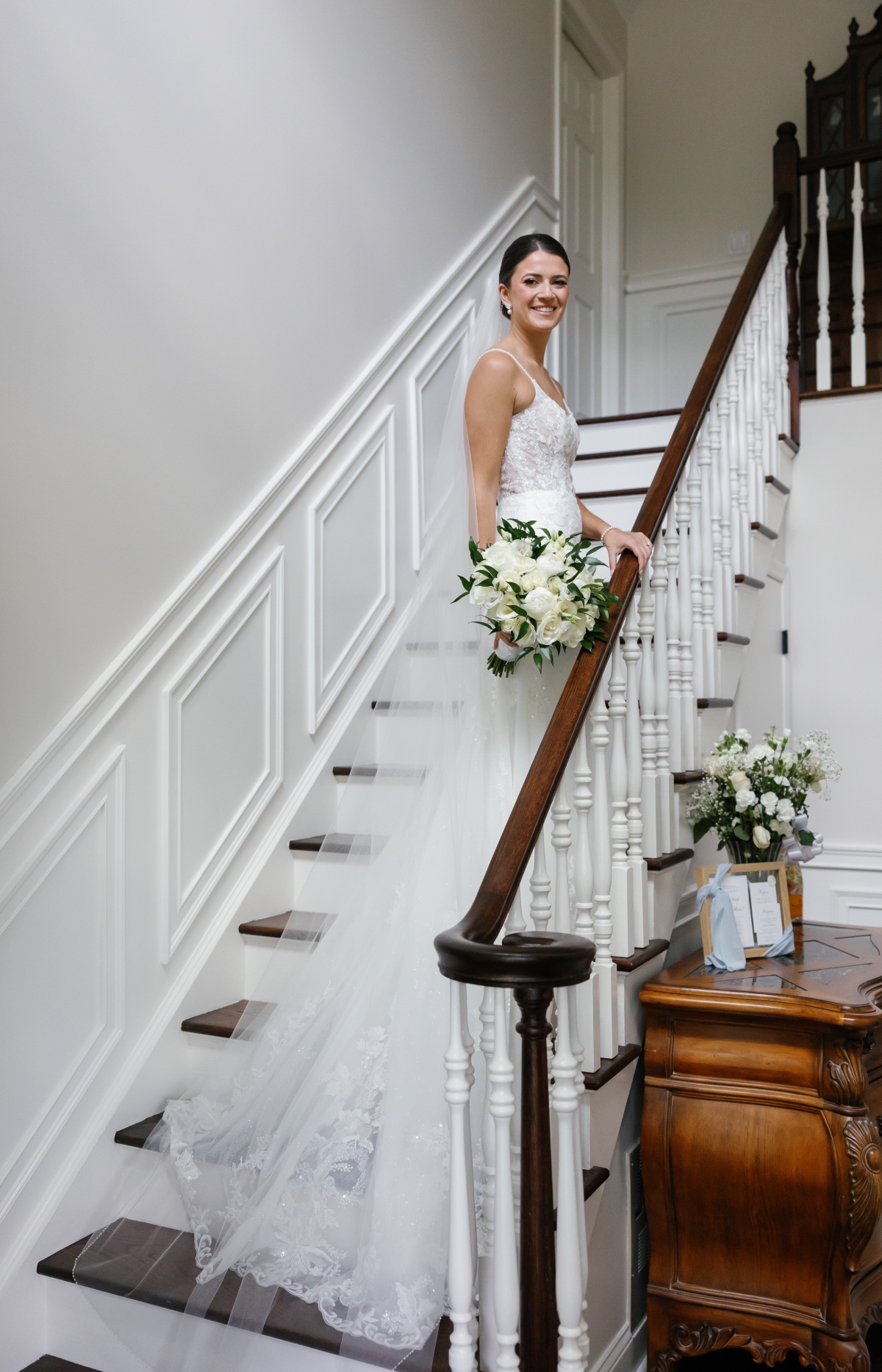 bride poses on family home staircase