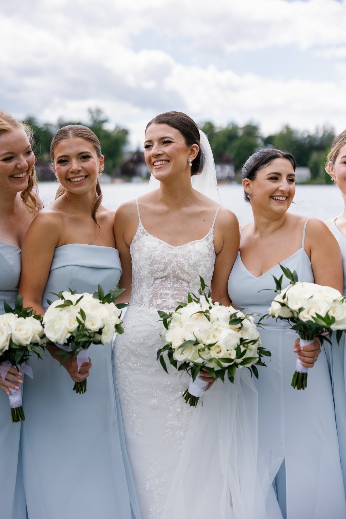 bride with bridesmaids in mix and match light blue dresses