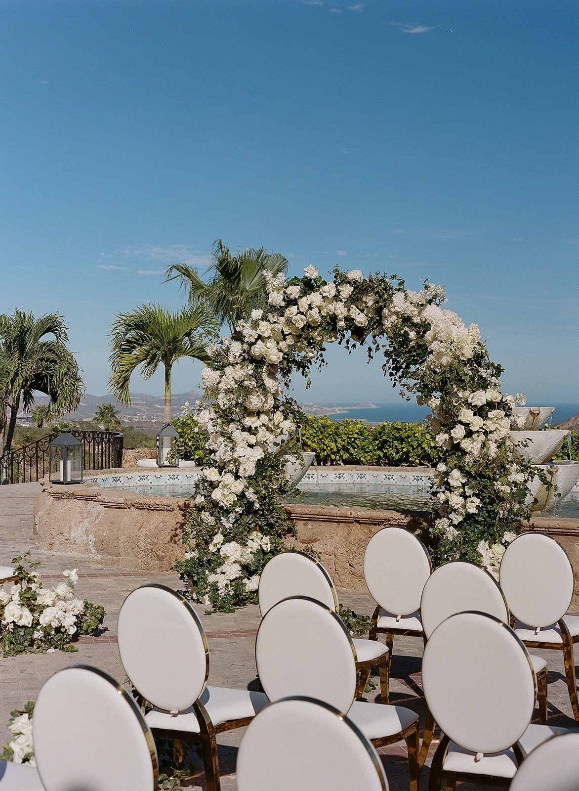 wedding ceremony in cabo with white rose arch