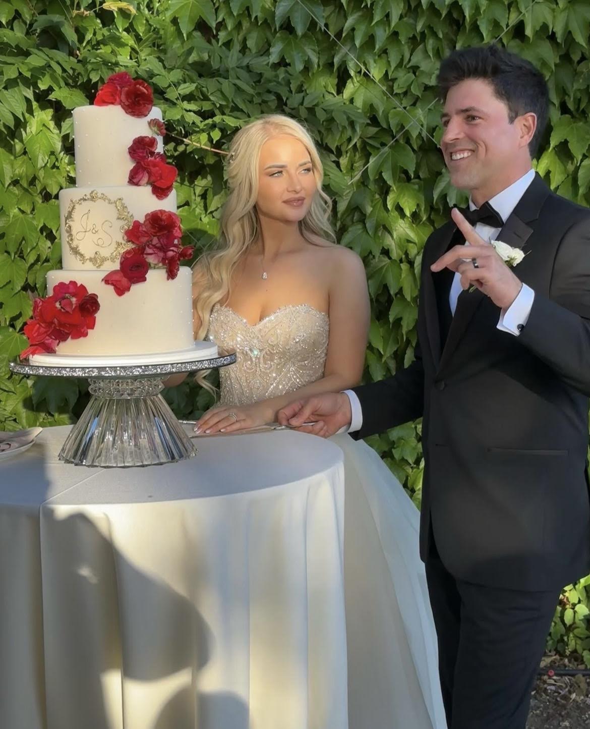 three tiered wedding cake with red flowers and fondant