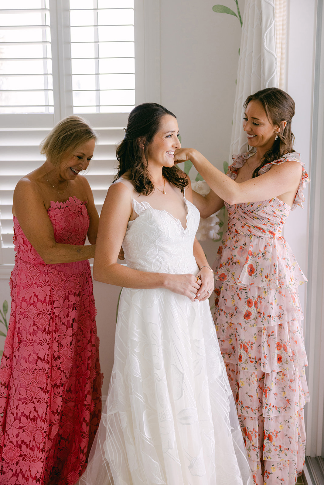 bride putting on white lace gown