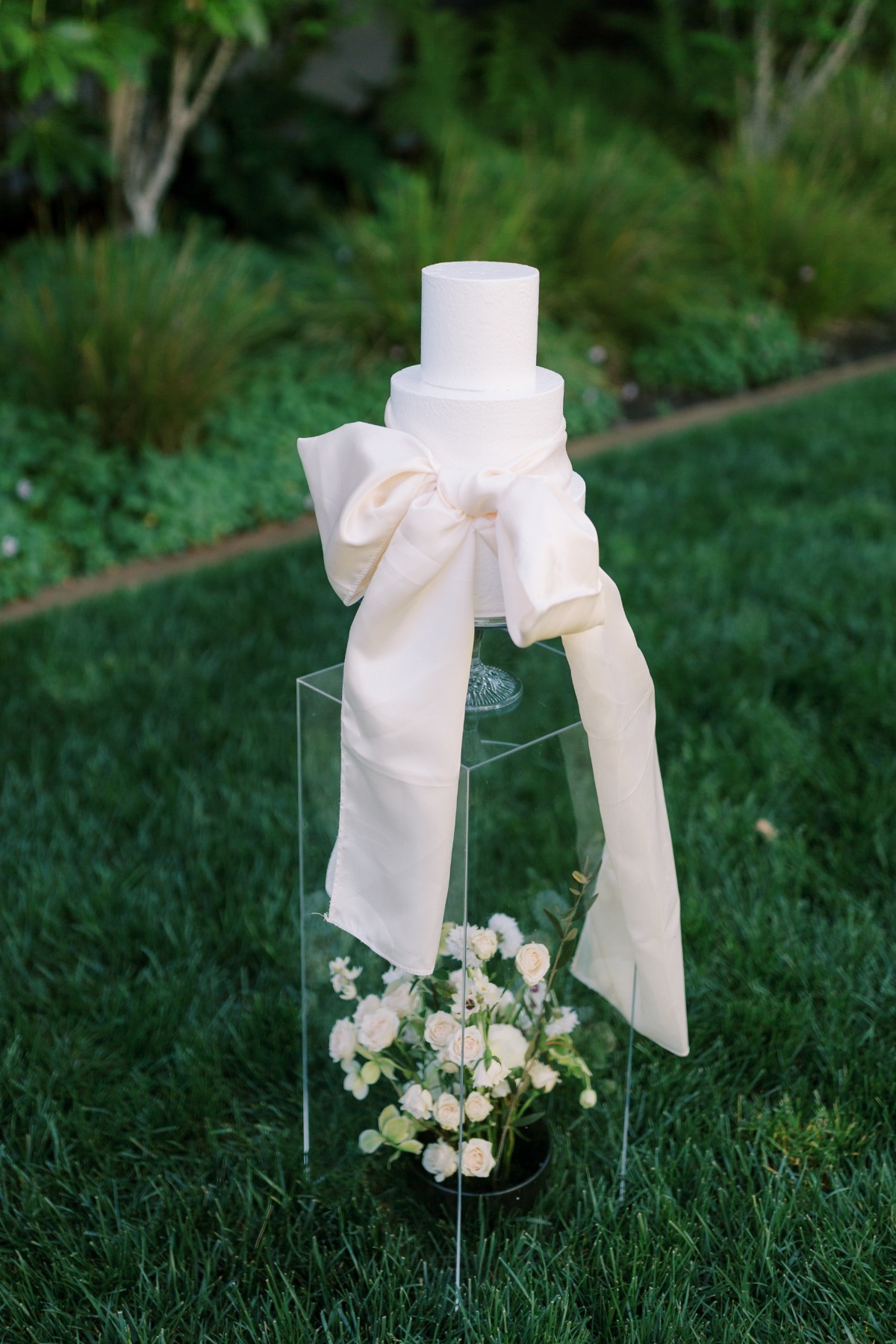 floating wedding cake on acrylic stand with bow