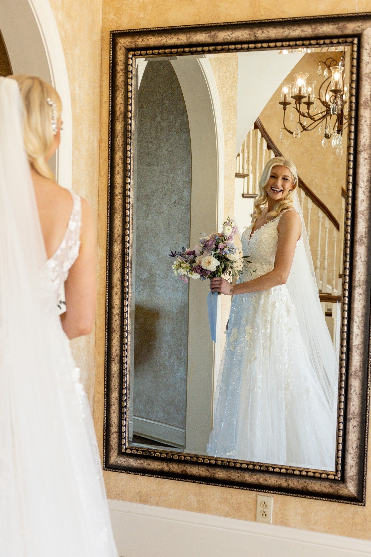 bride looking in gold mirror while getting ready