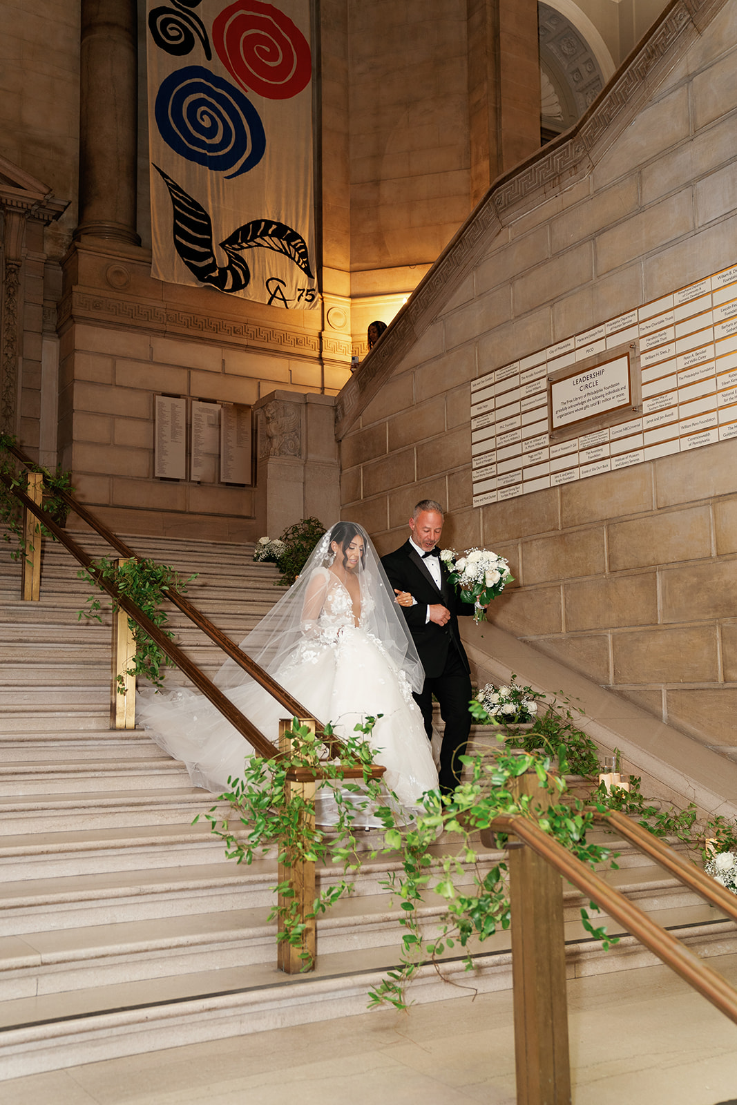 father walking bride down elegant staircase for wedding ceremony