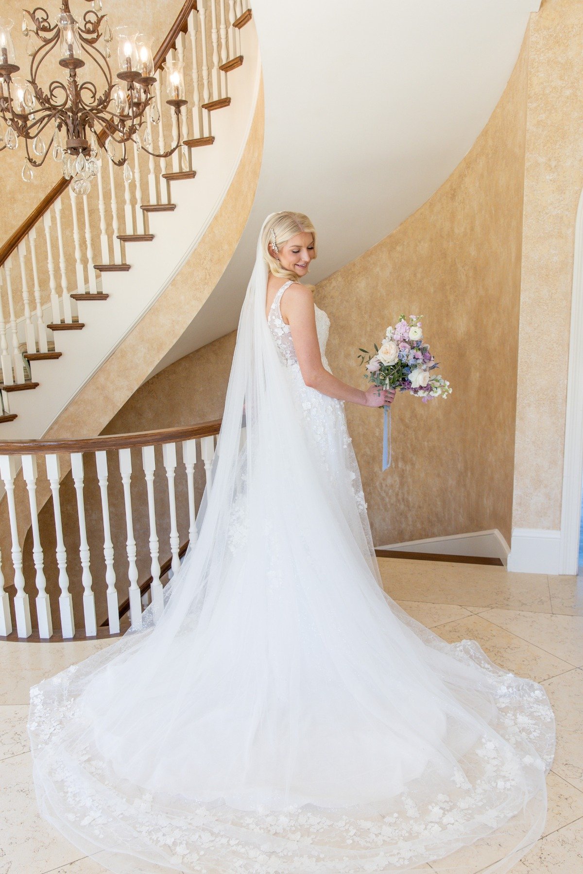 bride with veil walking down staircase