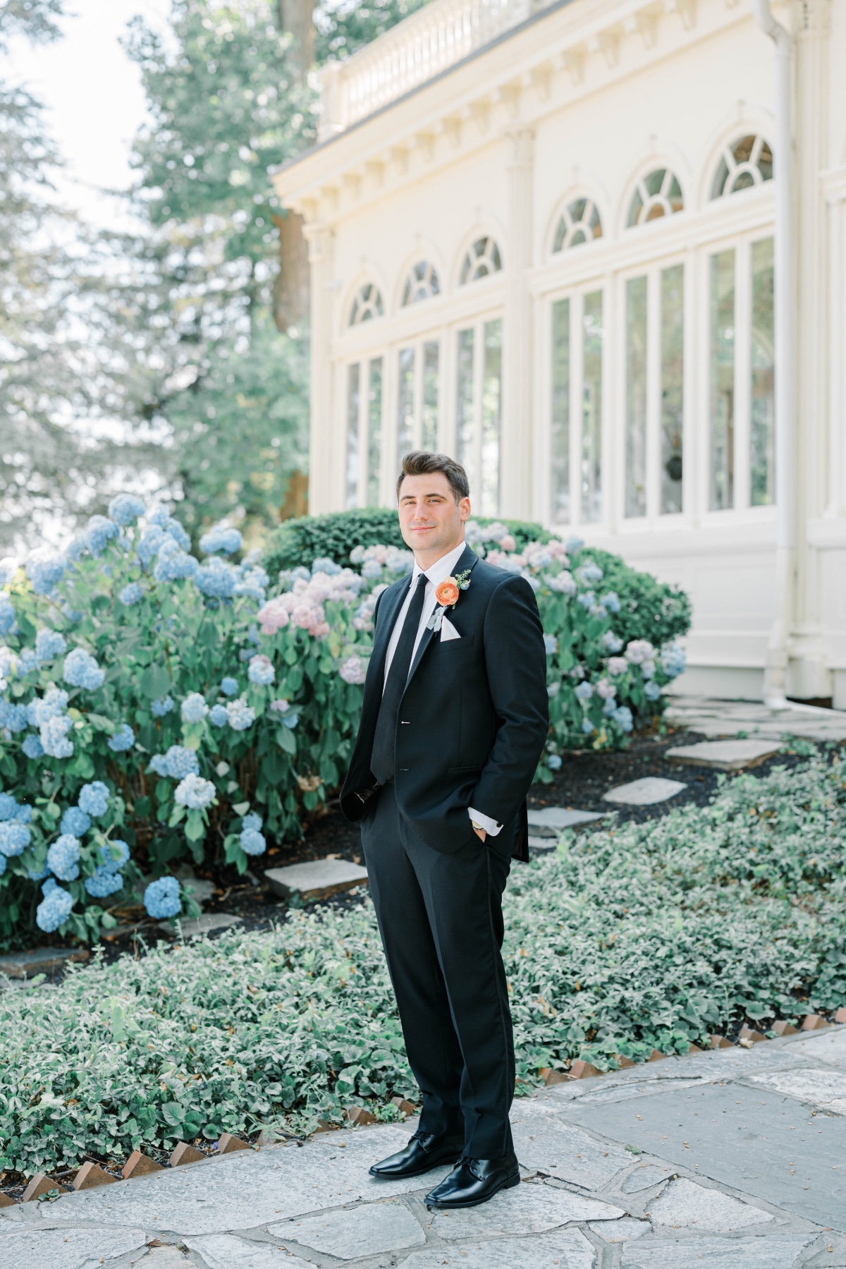 groom in a black suit with a pastel boutonnière 