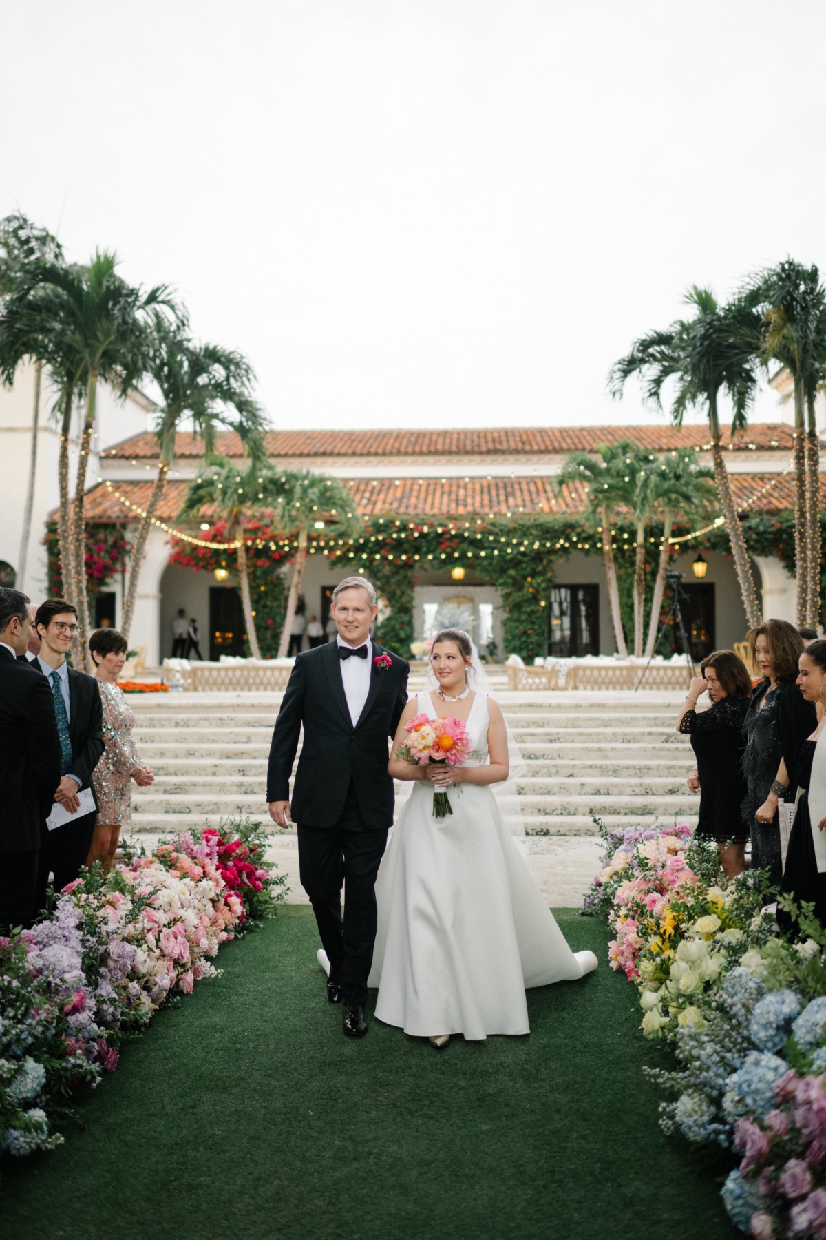 bride walking down the aisle at rainbow garden wedding