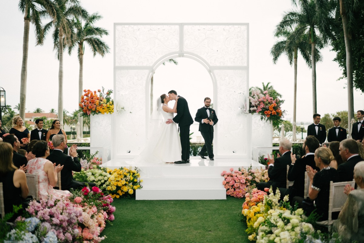 bride and groom kiss at rainbow wedding ceremony