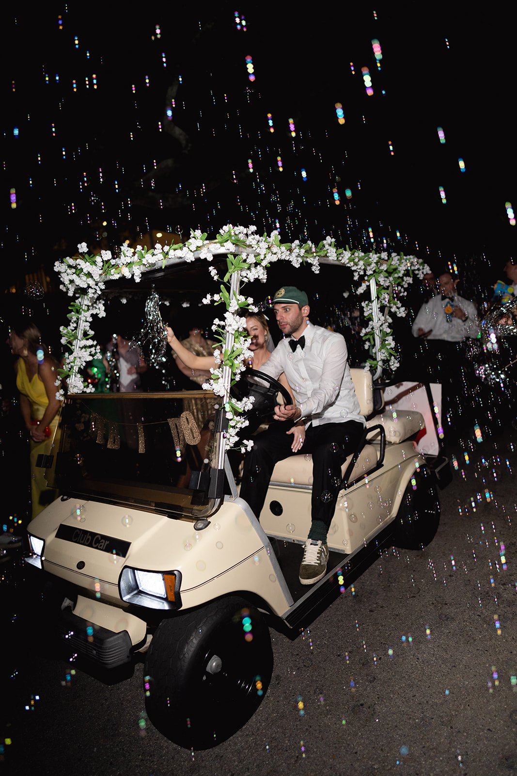 bride and groom exit in golf cart