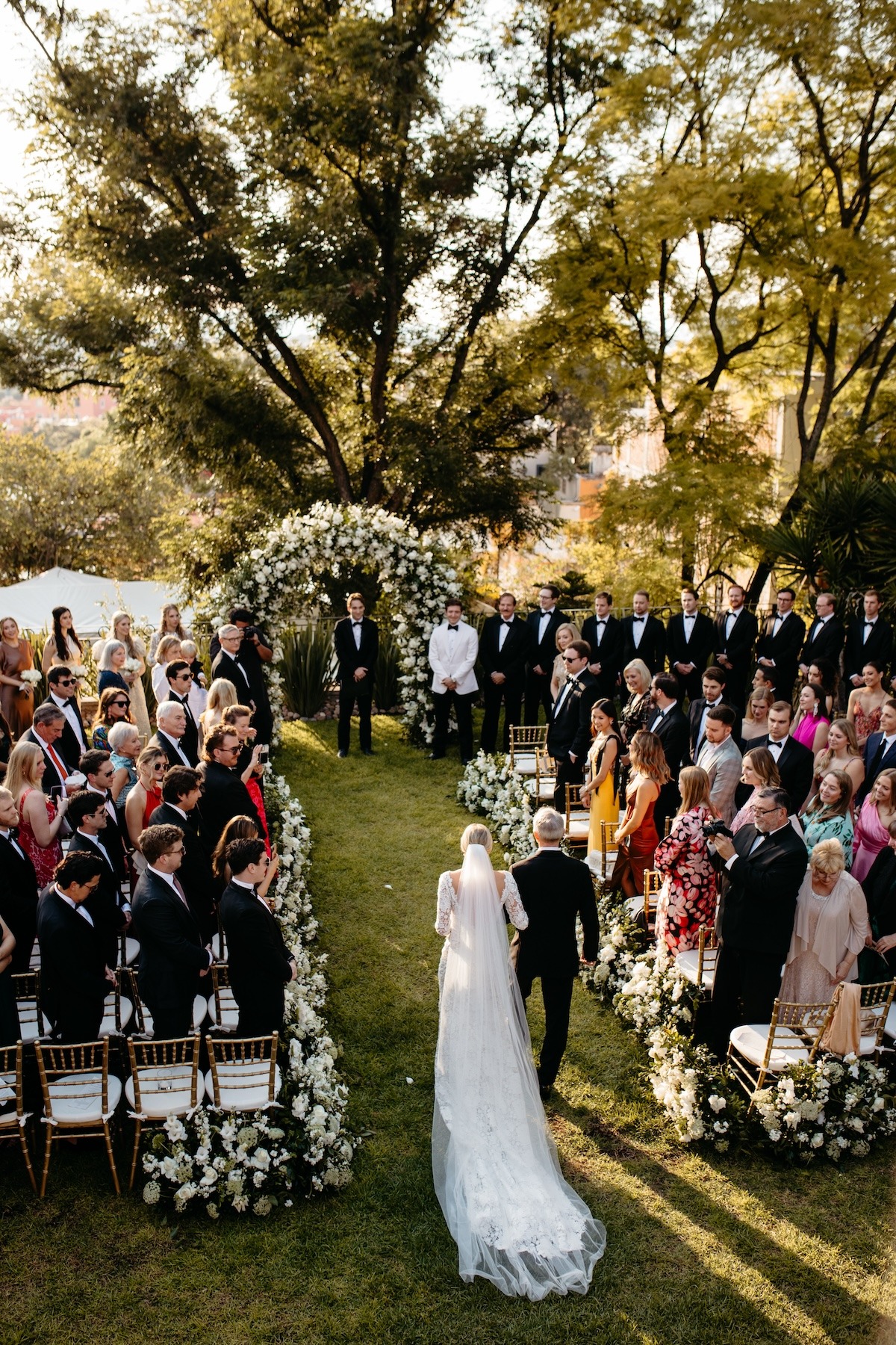 white floral arch for wedding ceremony in mexican garden