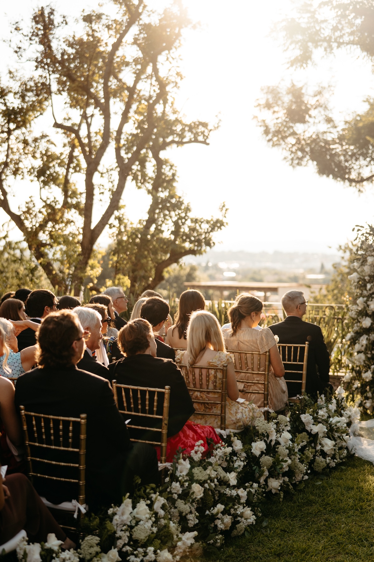 wedding ceremony with gold chairs and white flowers