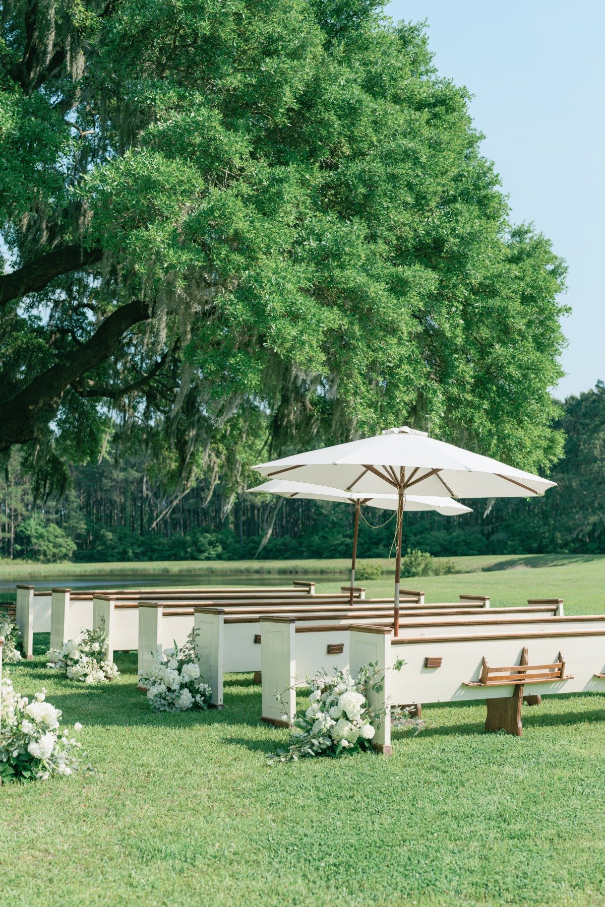 outdoor wedding ceremony with pews and sun umbrellas