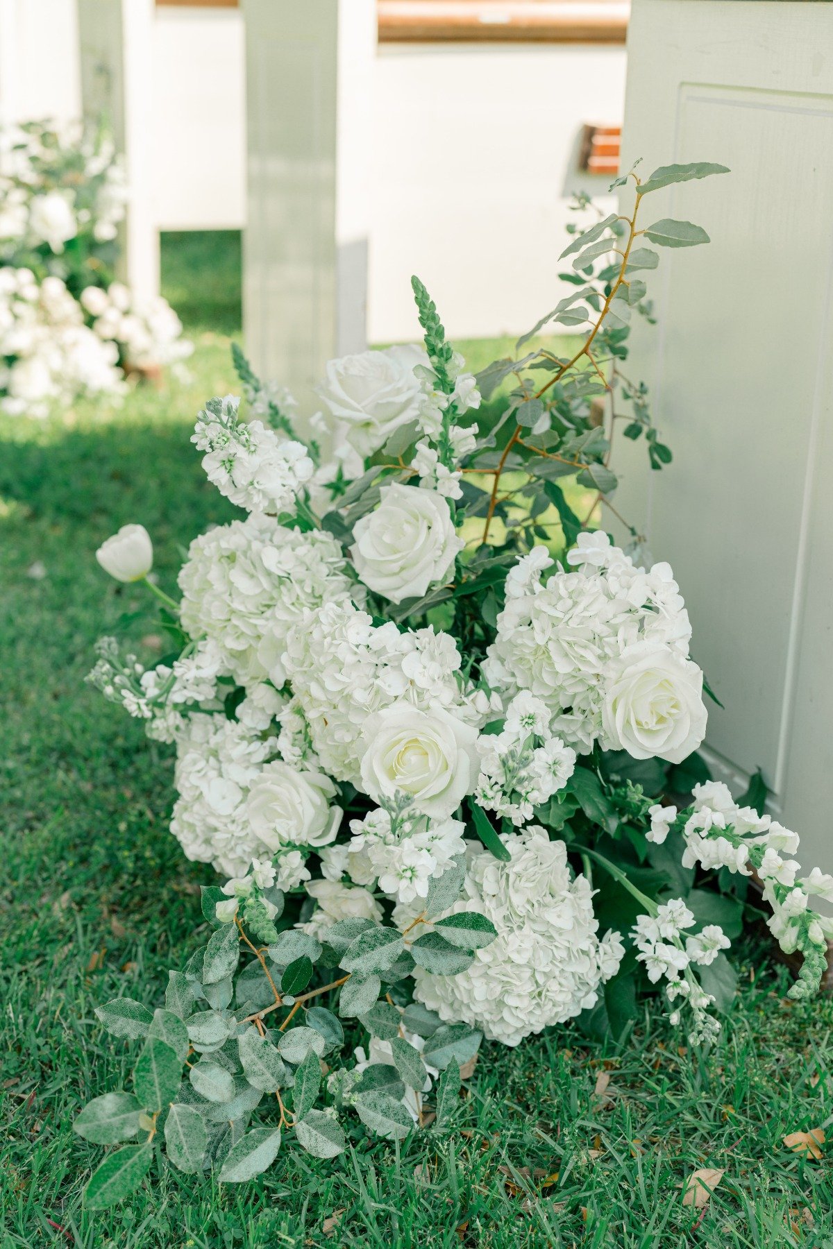 white flower arrangements on floor at wedding ceremony