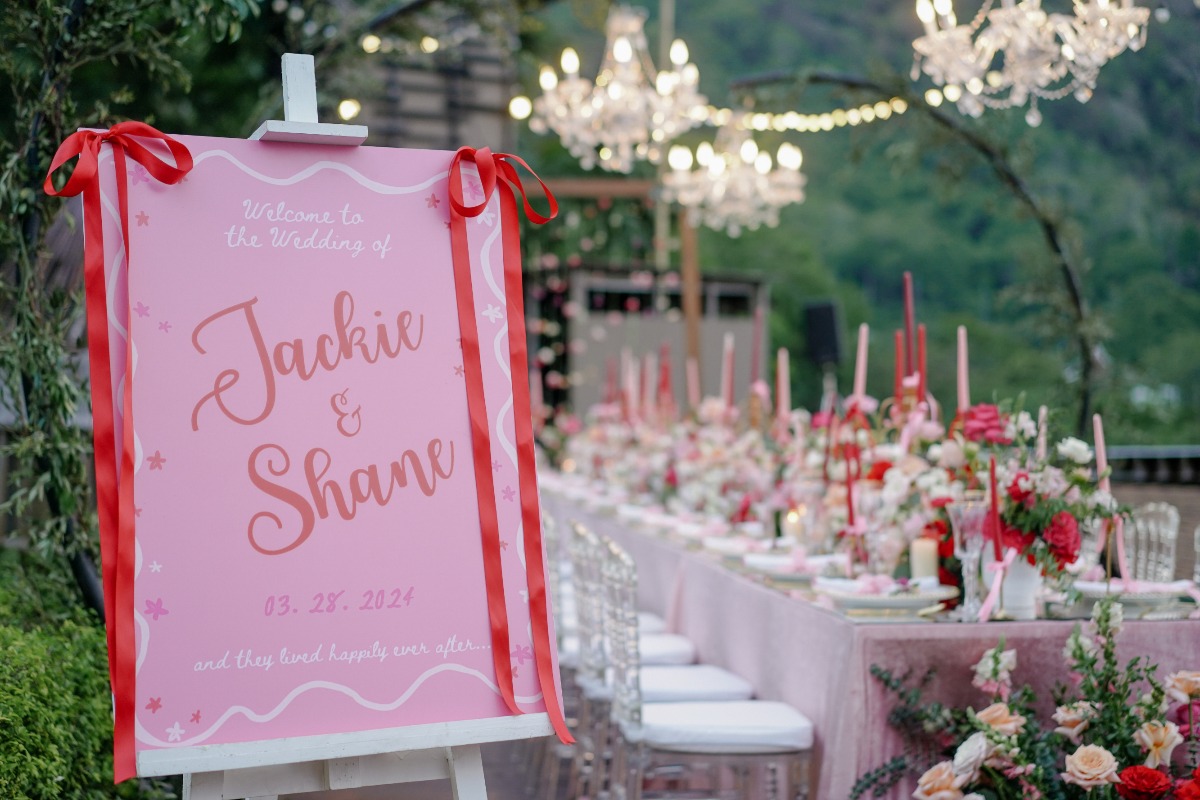 pink wedding welcome sign with red bows