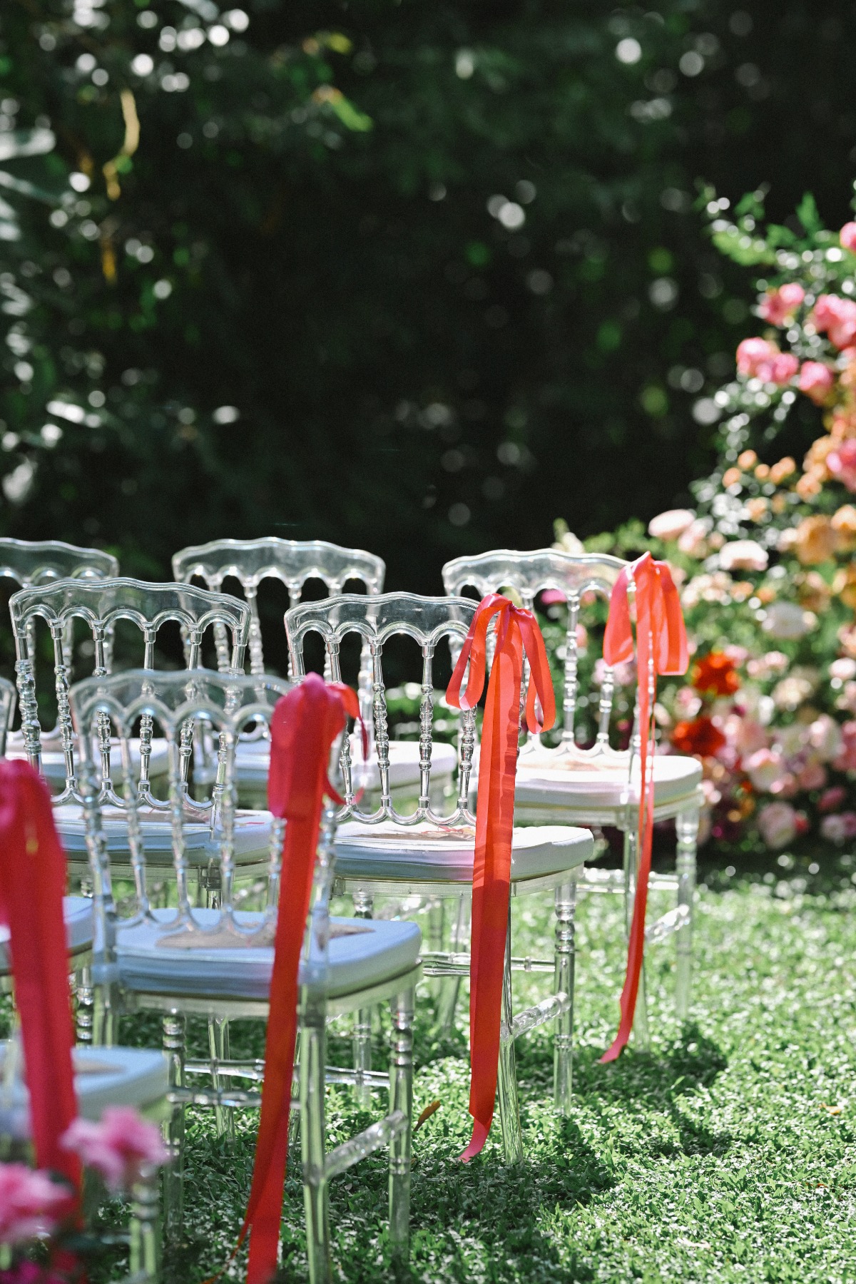 Clear chairs with red bows tied to each for a touch of whimsy