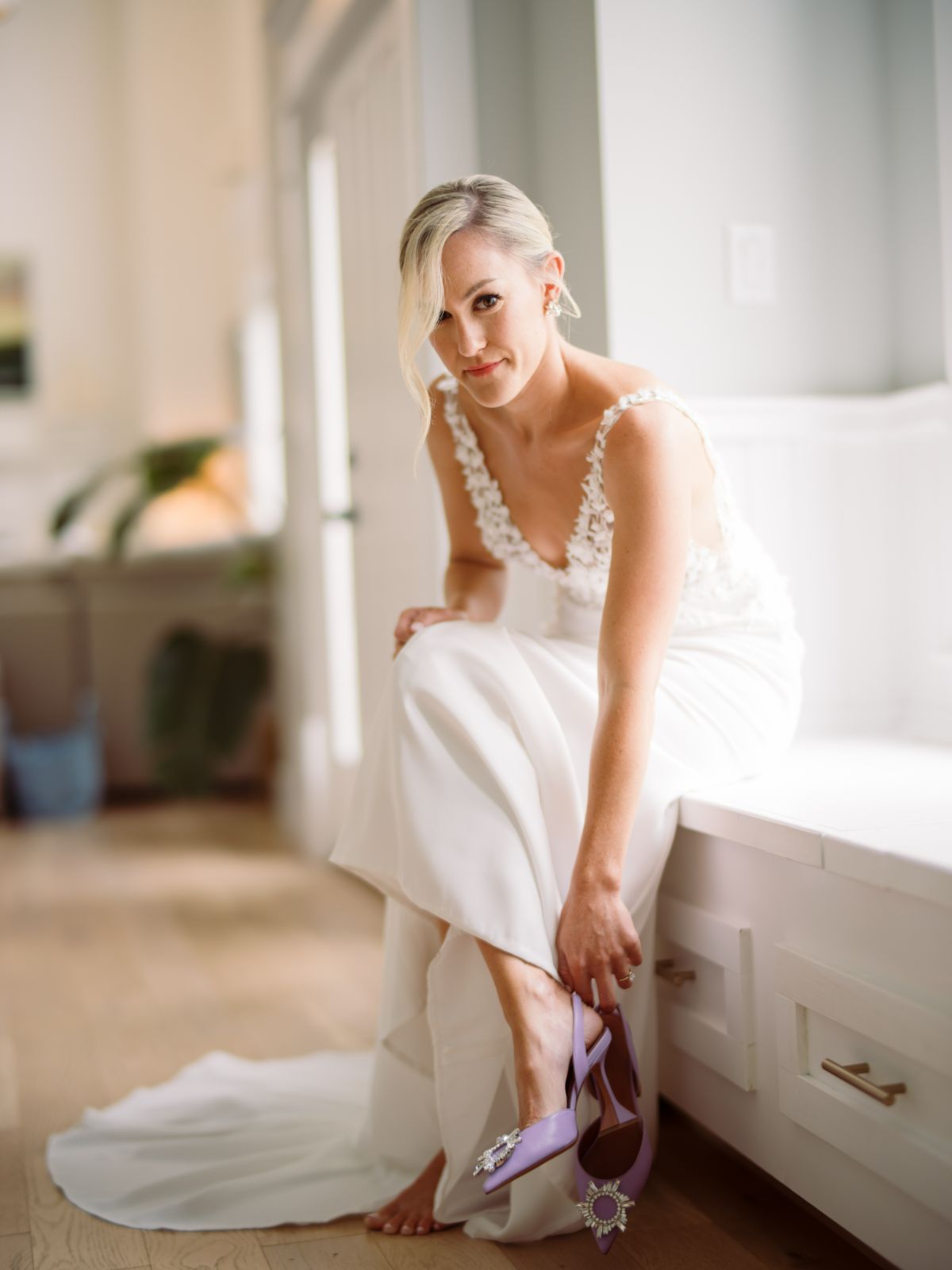 bride in lace wedding gown getting ready with purple shoes