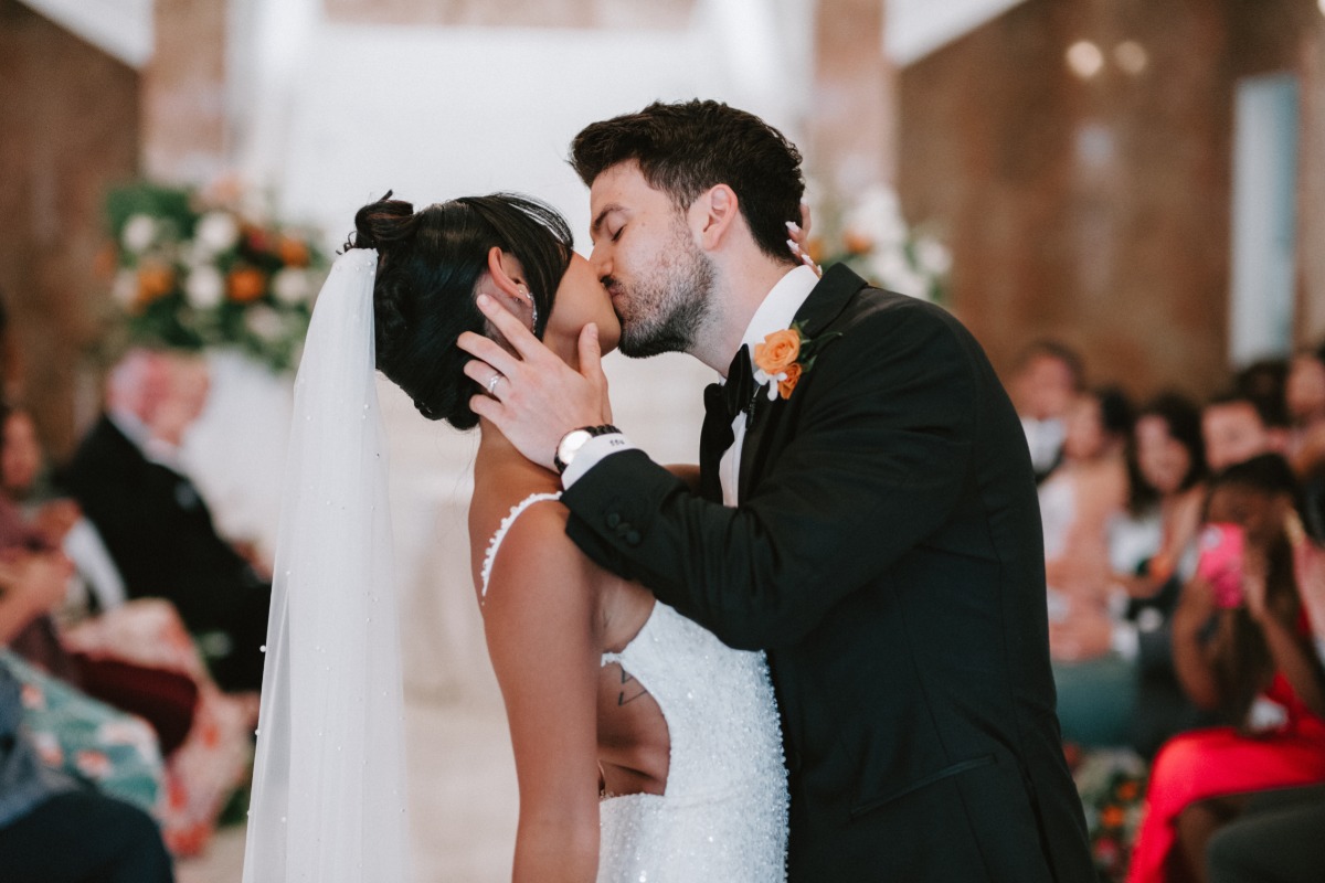 bride and groom kiss at tropical wedding ceremony