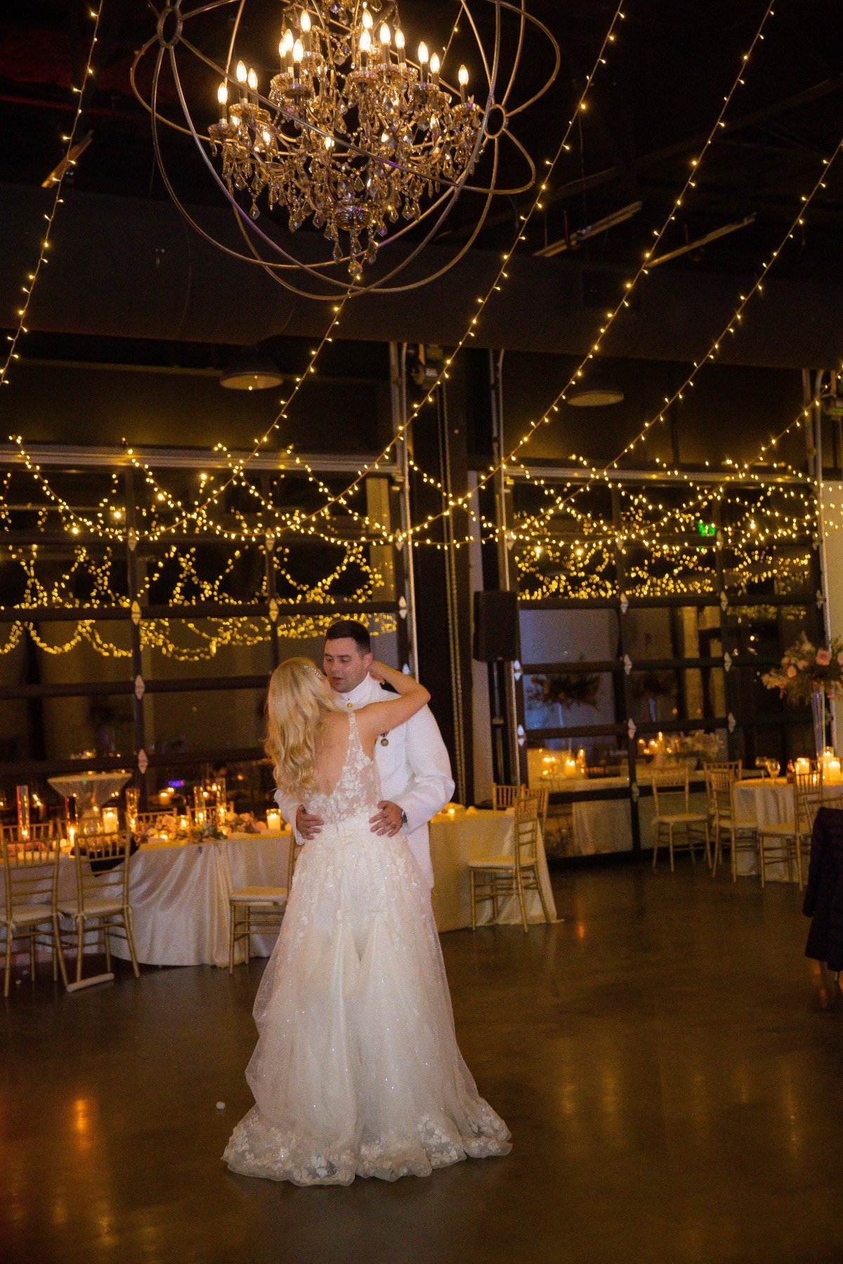 first dance for wedding under chandelier and twinkle lights