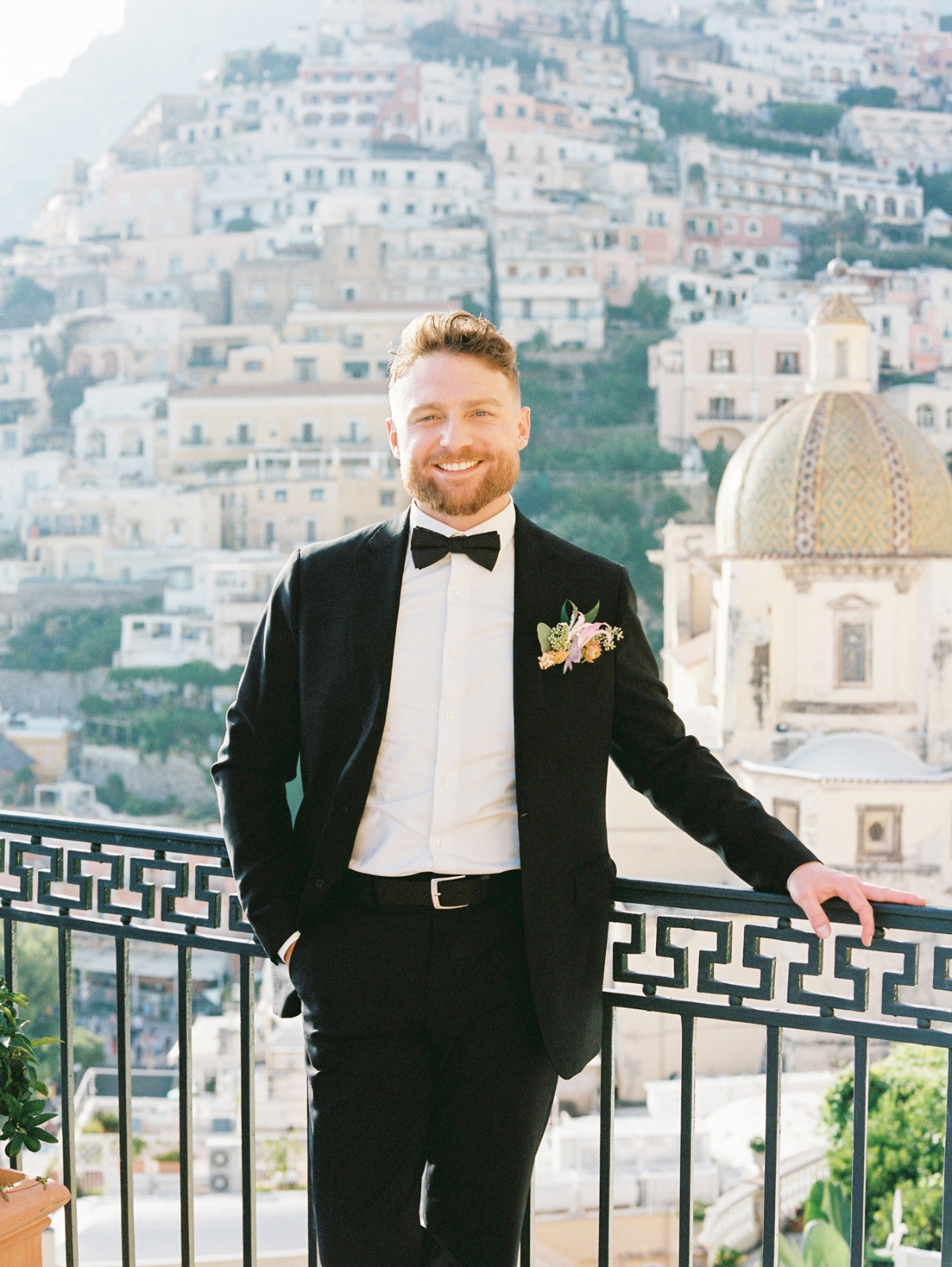 groom in black tuxedo at hotel overlooking positano