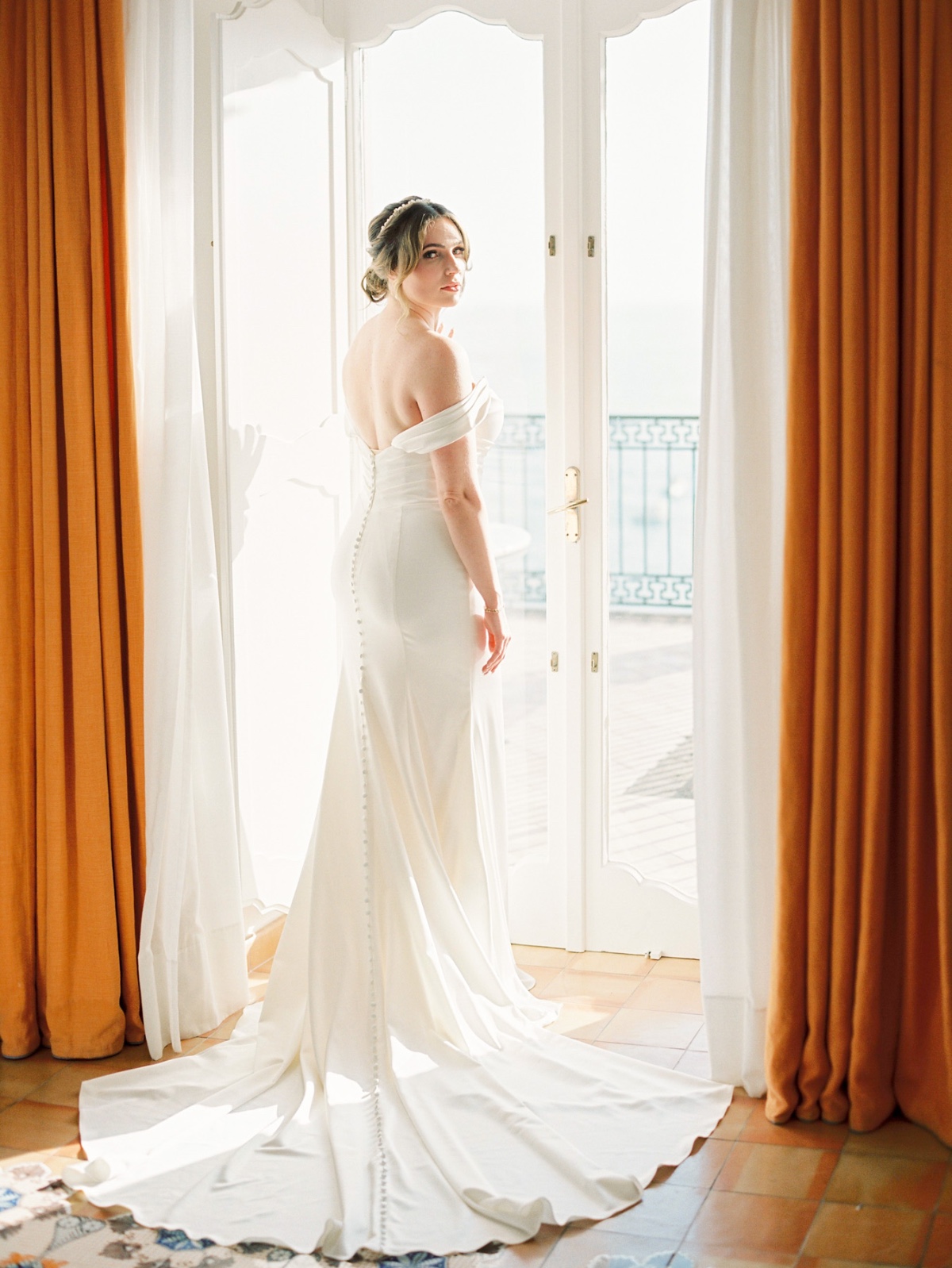 bride in off the shoulder wedding gown at hotel in positano