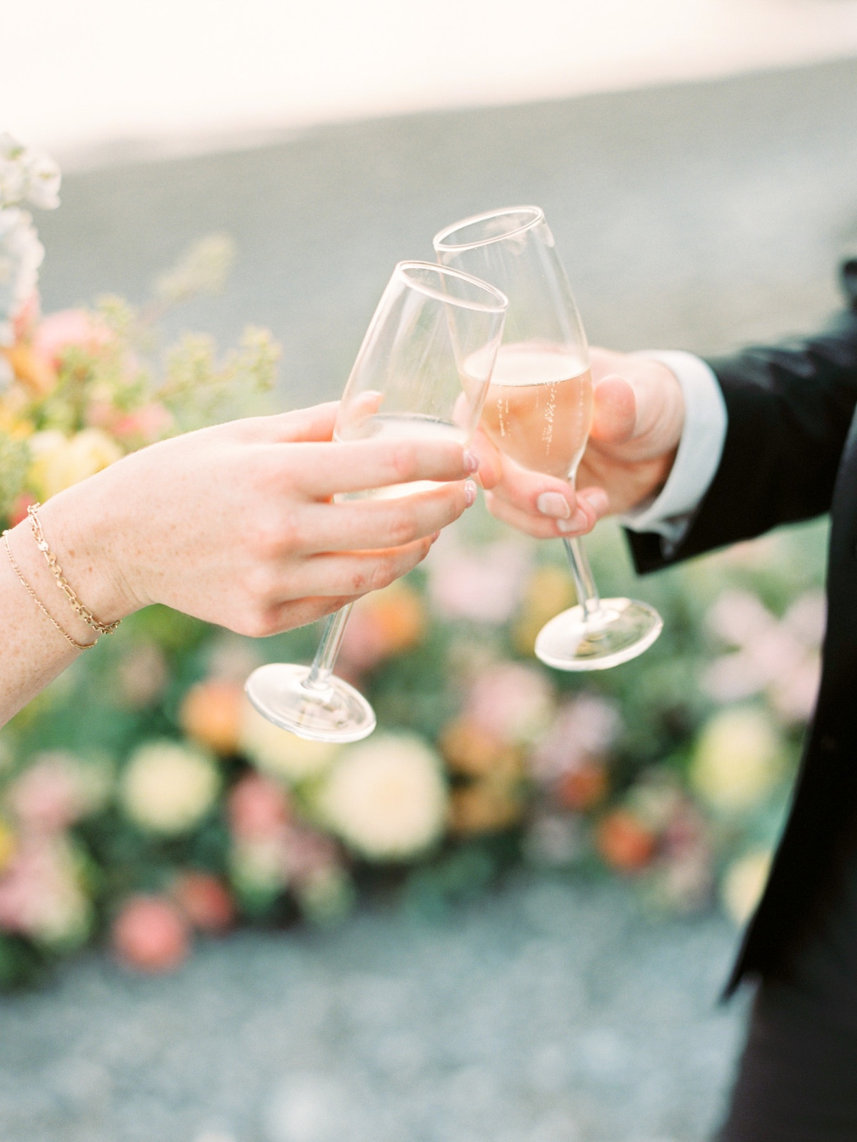 bride and groom toast with champagne flutes on beach