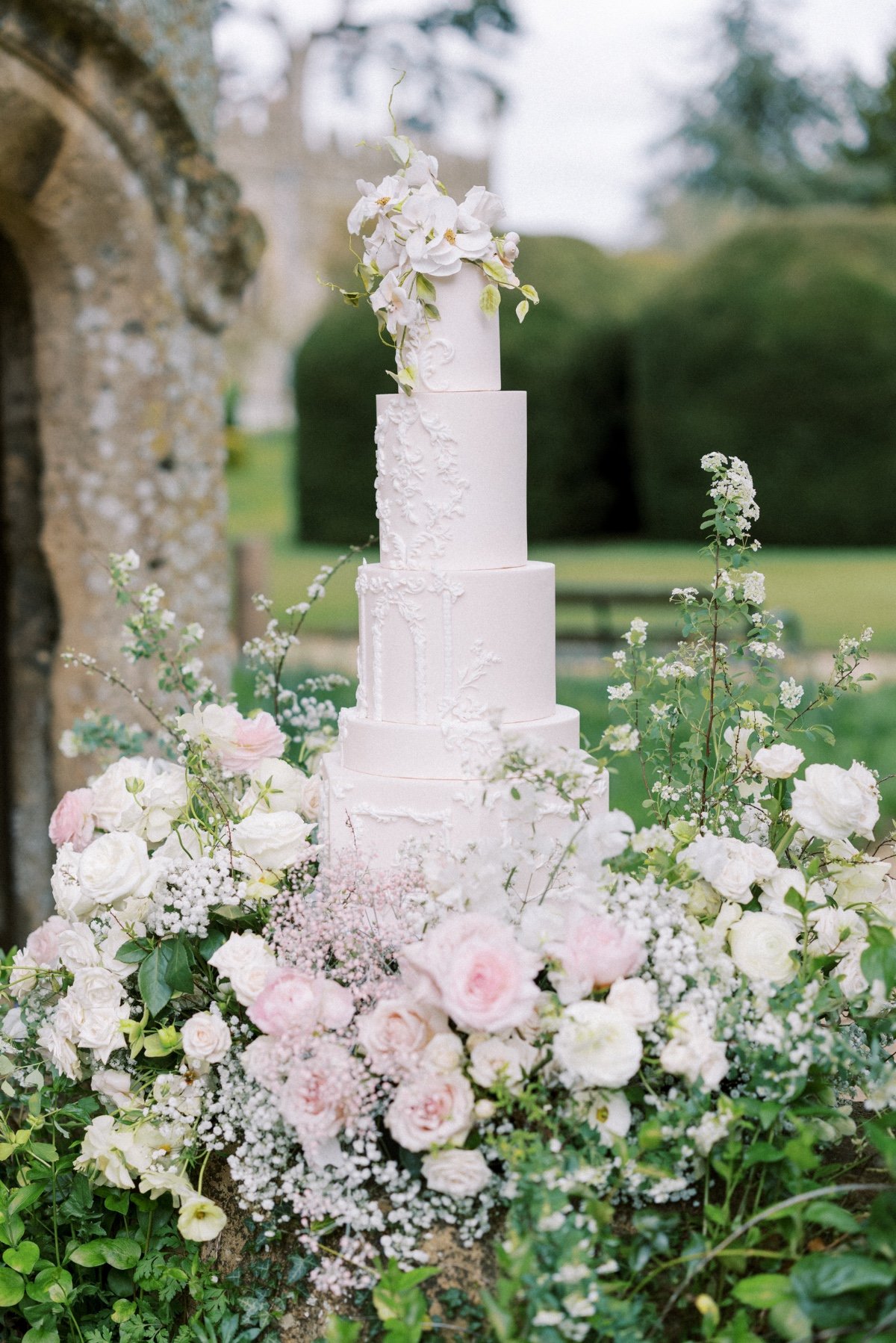 all white wedding cake with floral topper