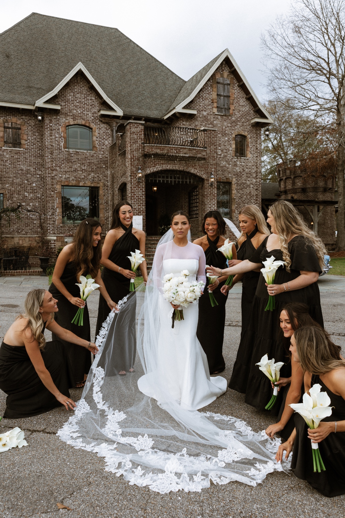 bride in minimalist wedding gown and bridesmaids in black