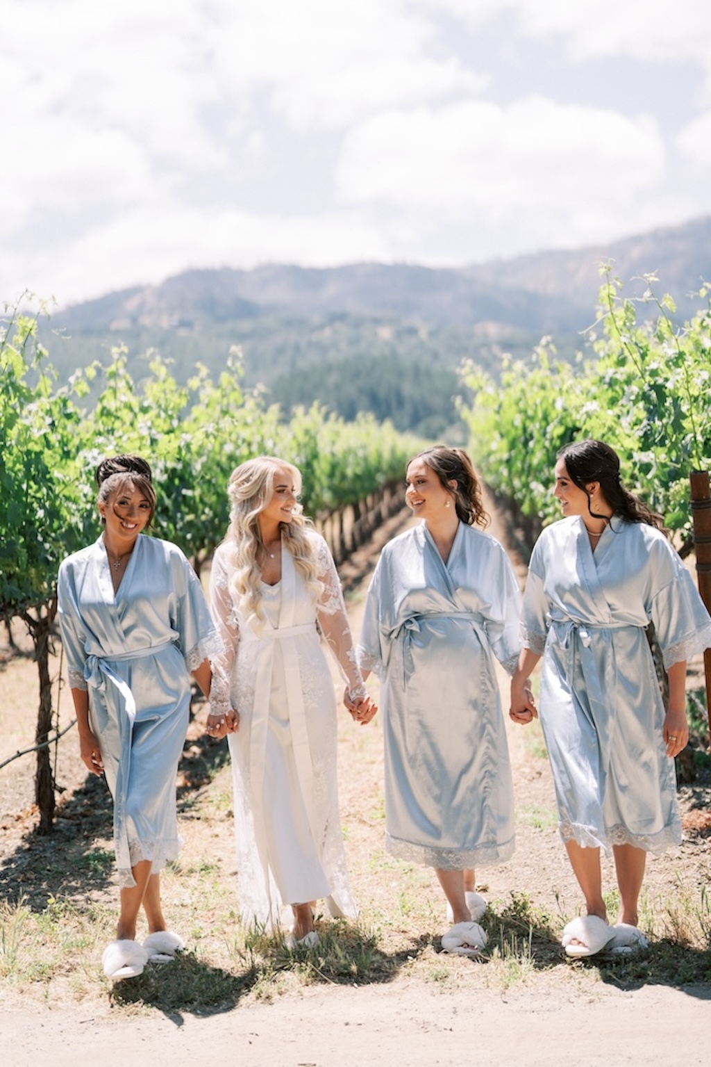 bride in lace robe and bridesmaids in blue satin robe