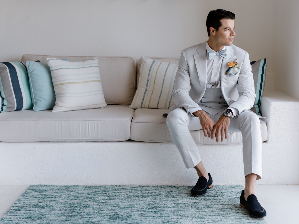 groom in gray suit getting ready