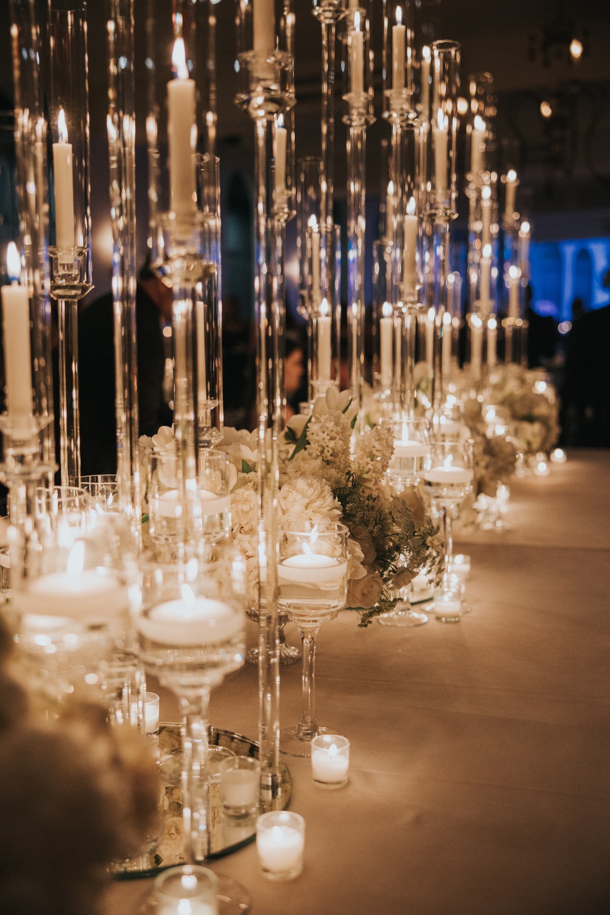 glass hurricane holders for tapered candles at wedding reception