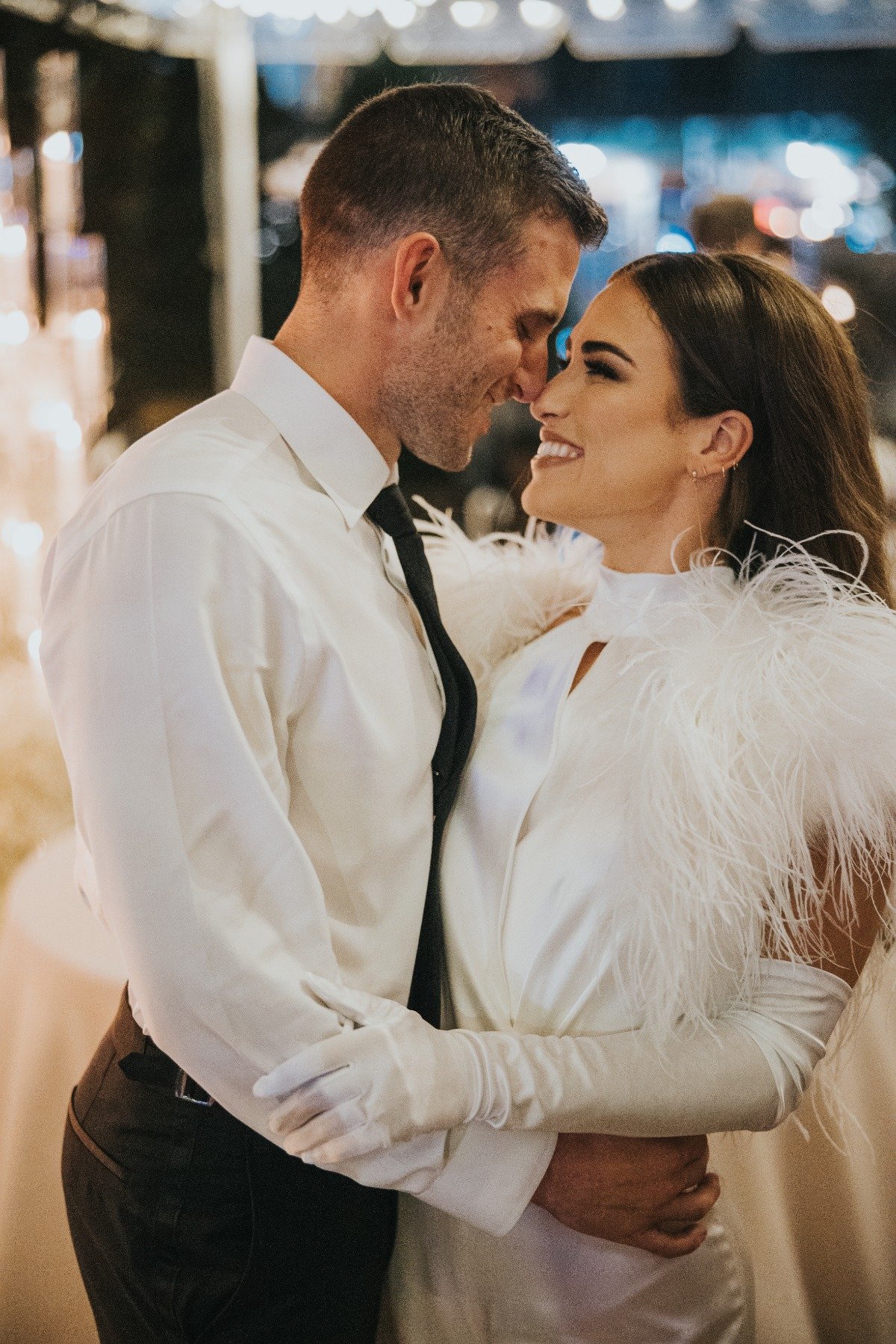 bride in feathered jumpsuit for wedding reception