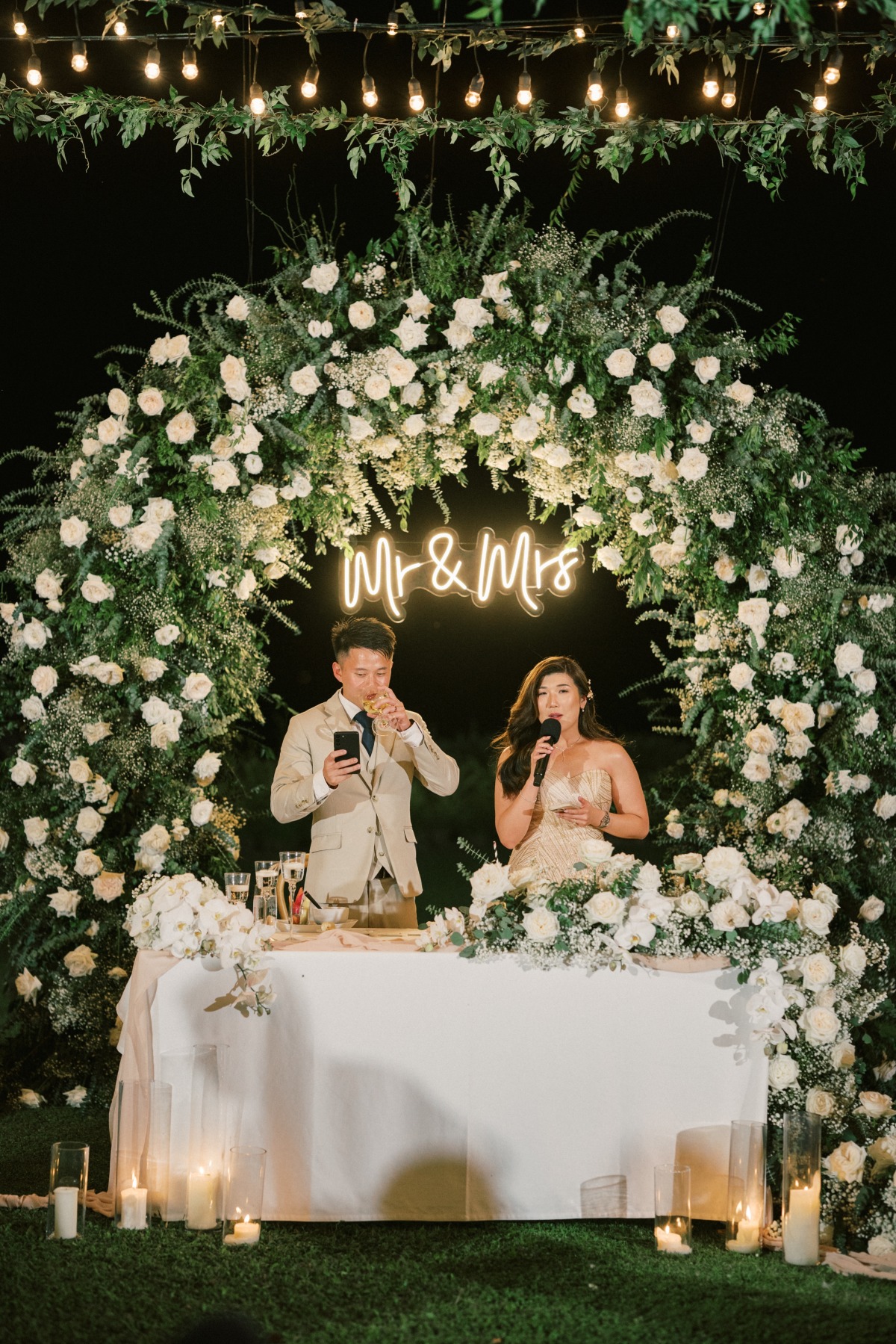 sweetheart table with large white rose floral arch