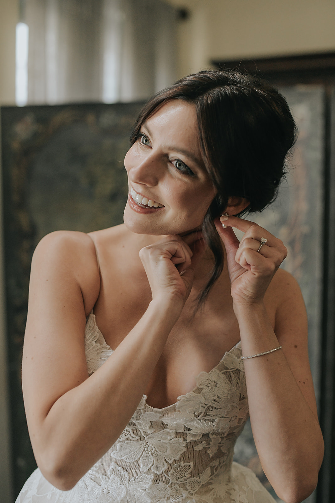 bride getting ready for wedding with lace dress