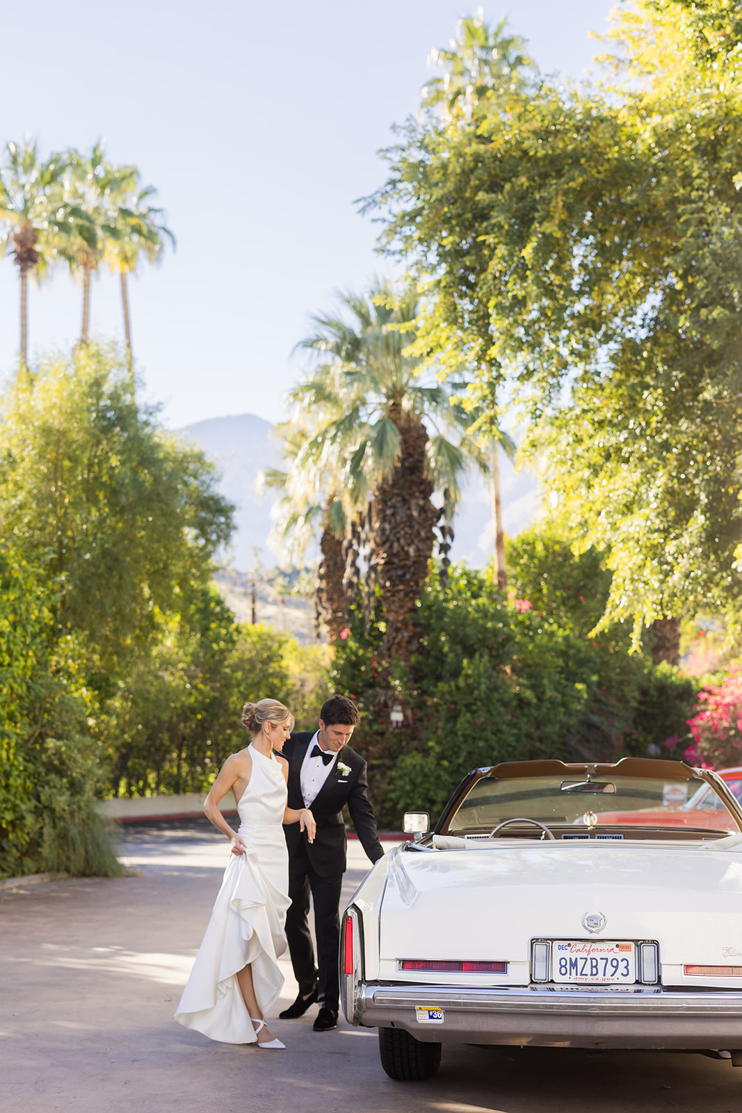 bride and groom getting into vintage car