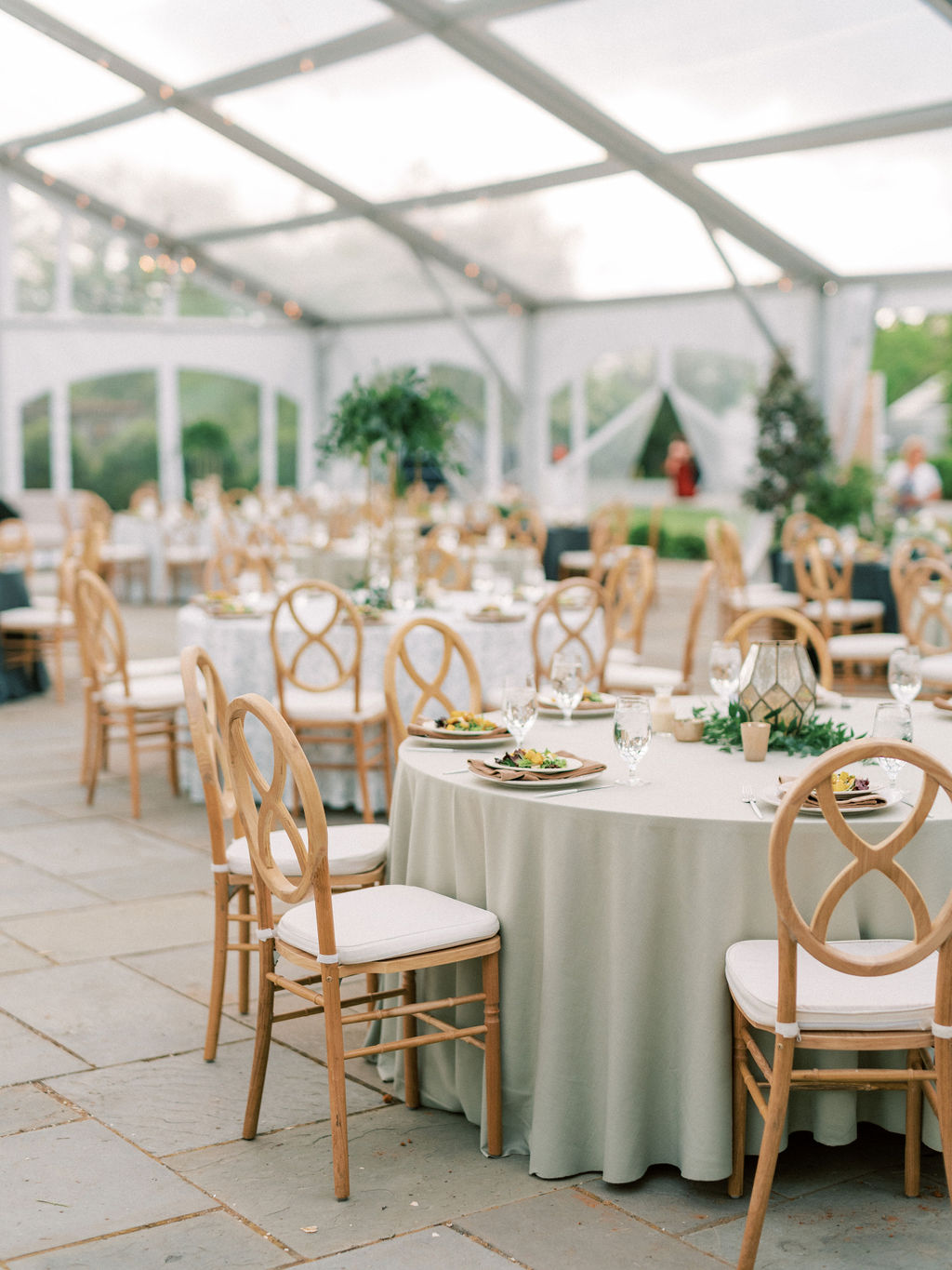 clear tented wedding reception in green and peach