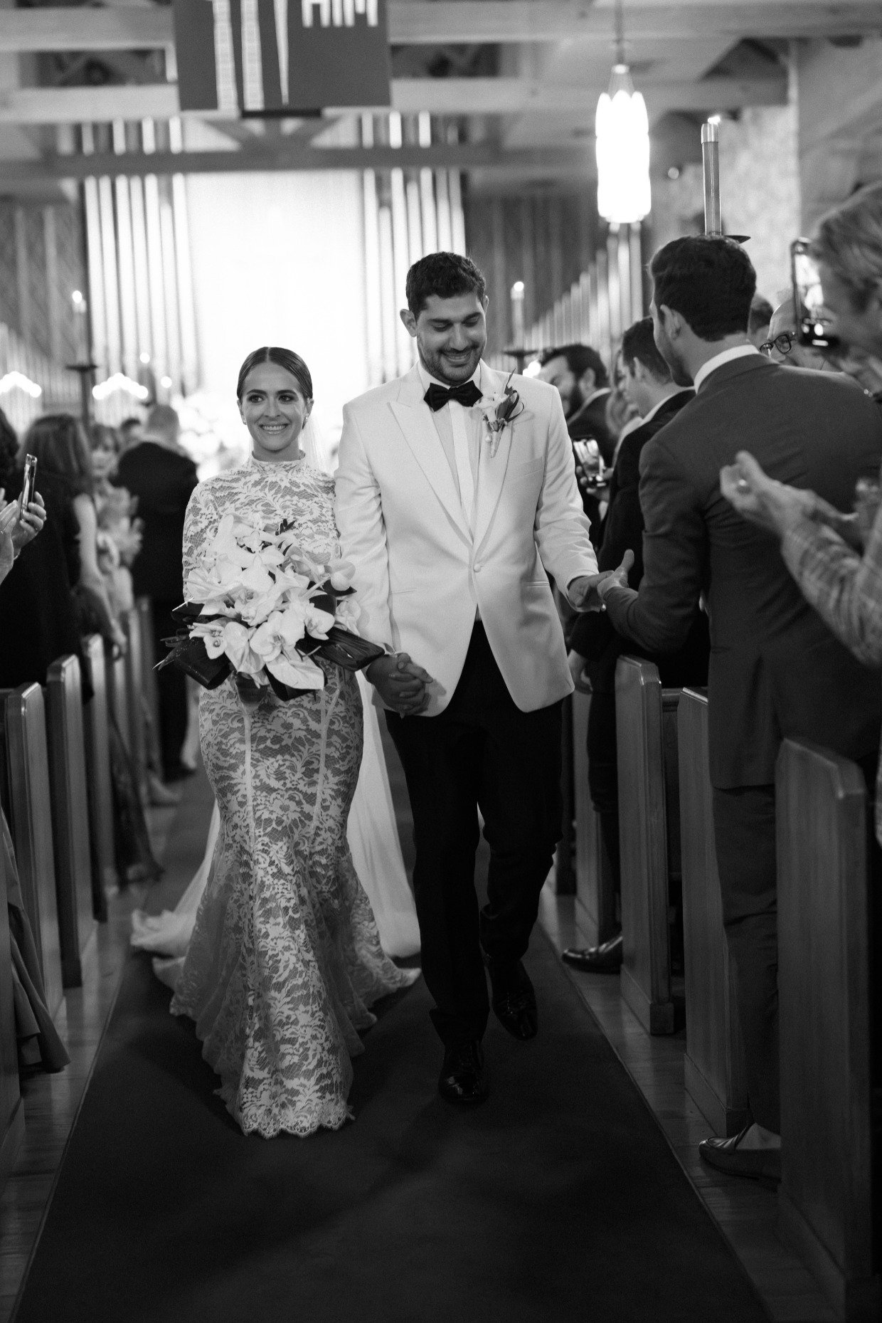 bride and groom walk down aisle in galia lahav wedding gown