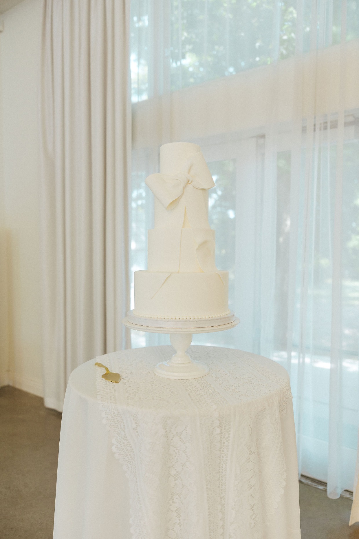 white wedding cake with bow from with great love planners