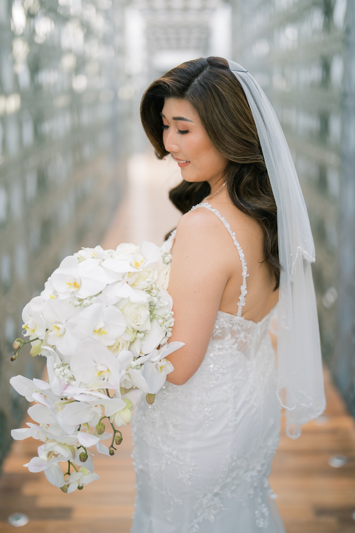 bride with white orchid bouquet for wedding